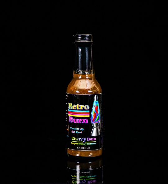 Hot Sauce in a black box with reflection underneath
