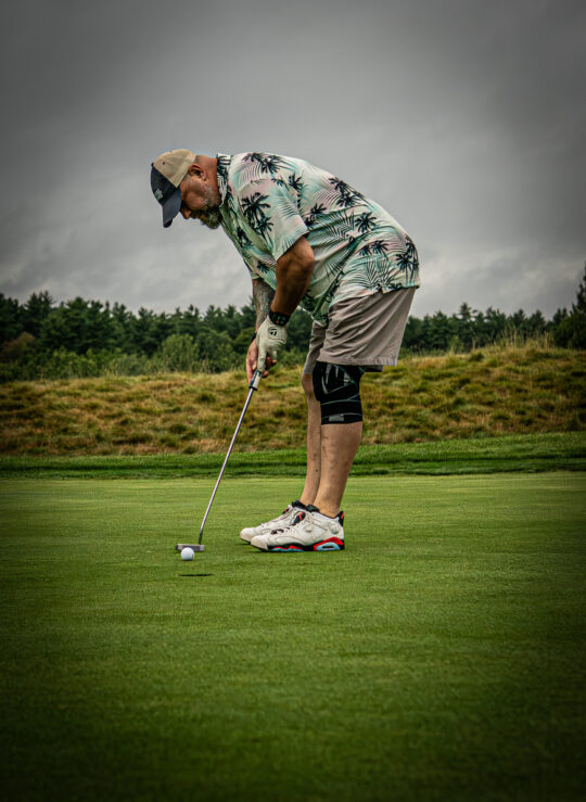 Male golfer putting on a golf course