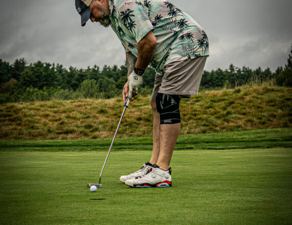 Male golfer putting on a golf course