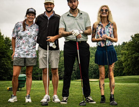 Portrait of golfers on a golf course holding golf clubs. Two men and two woman