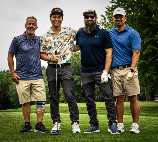 Four Men on a golf course taking a portrait